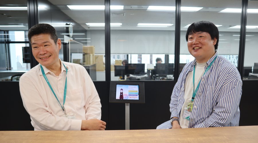＜左：上司の鈴木さん 右：「こみゆ」開発者の技術統括本部 システム開発本部の張（チャン）さん＞