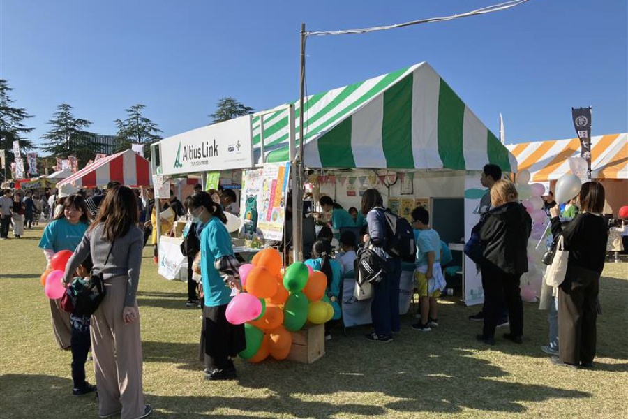 ＜ 青空の下に設置されたアルティウスリンクの出展ブース ＞