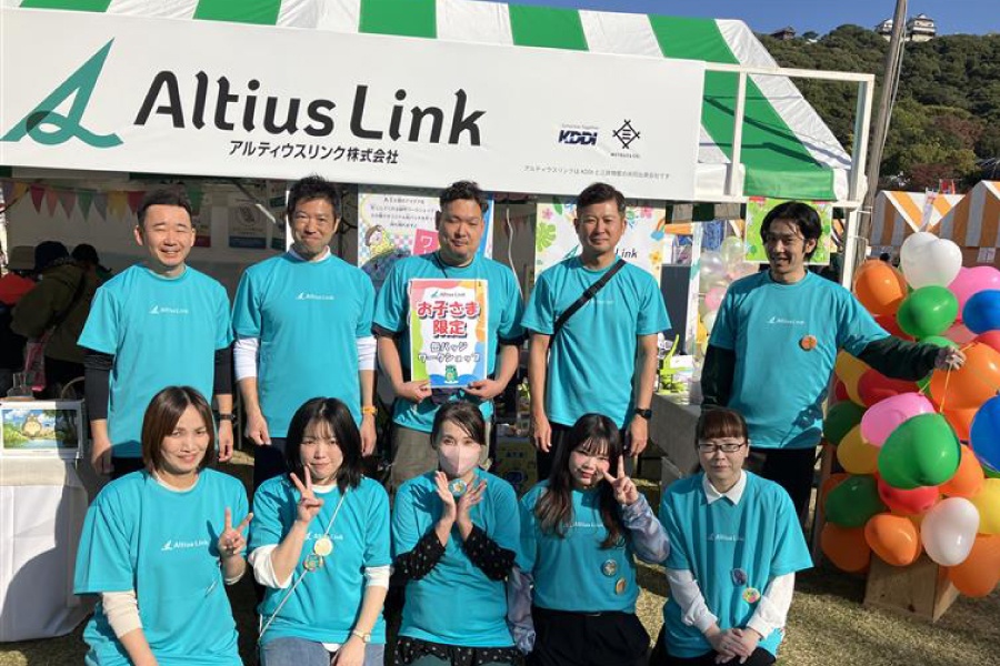 ＜ ブースの前でスタッフ揃って記念撮影。写真右上に小さく写っているのは松山城です！ ＞